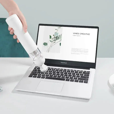 A person using a spray bottle to spray a laptop