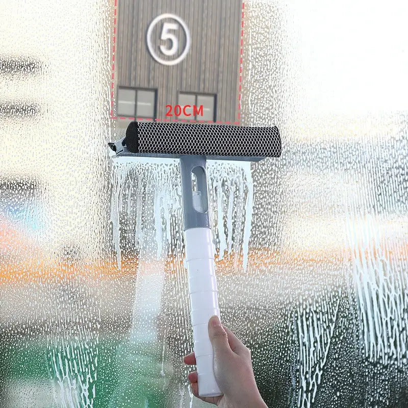 a hand holding a spray gun in front of a window