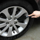 a person using a tire polisher to clean the rim