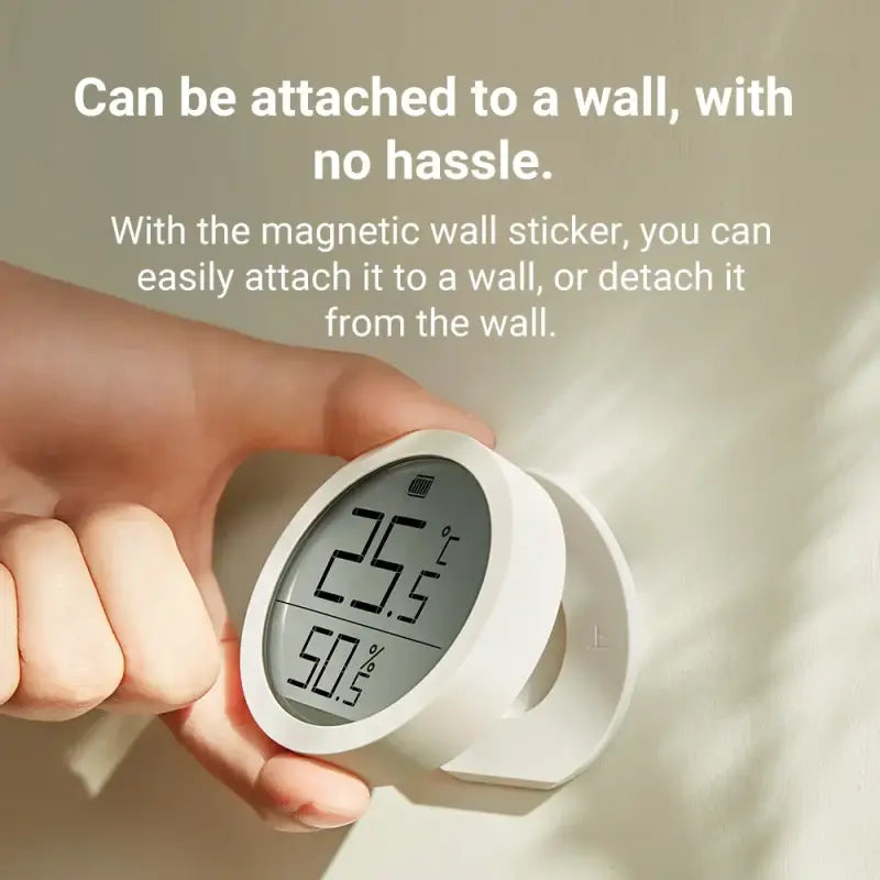 a person holding a white alarm clock