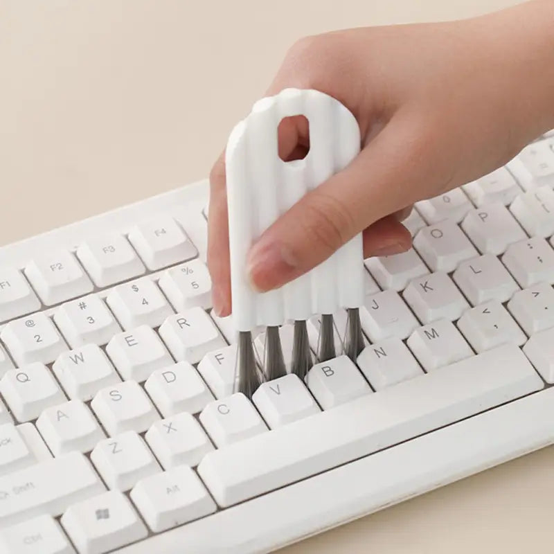 a person using a white plastic pen to write on a keyboard