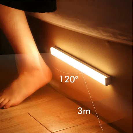 A person standing on a wooden floor with a light on it