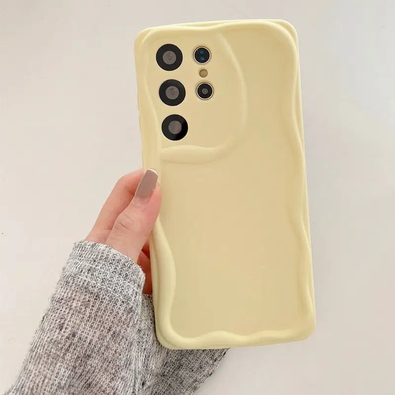 a person holding a yellow phone case