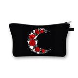 a black cosmetic bag with red roses and a crescent