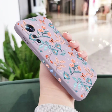 a woman holding a phone case with a floral pattern