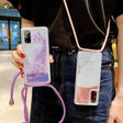 Someone holding a phone case with a purple cord attached to it