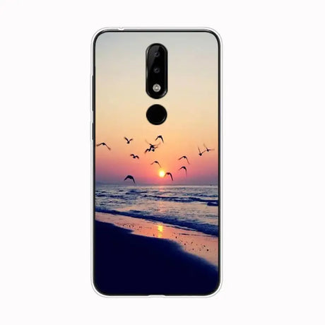 a phone case with a sunset and birds flying over the beach