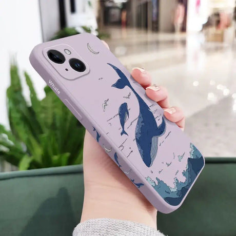 a woman holding a phone case with a whale on it