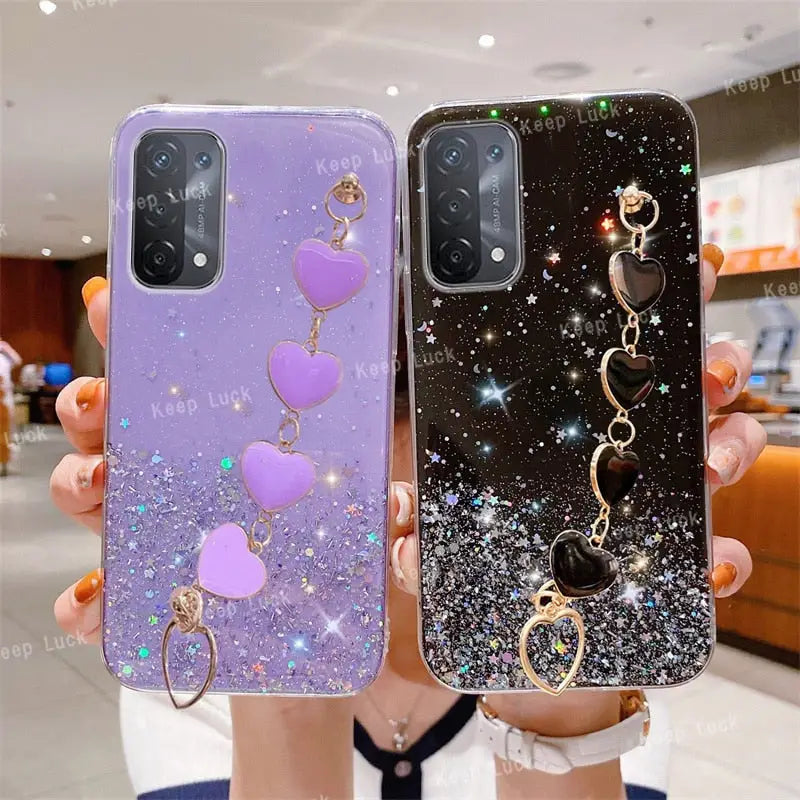 a woman holding two phone cases with heart charms