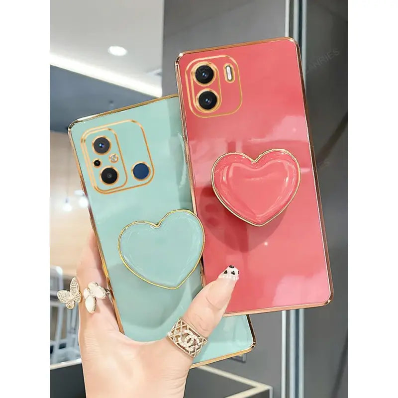 two phone cases with heart shaped charms