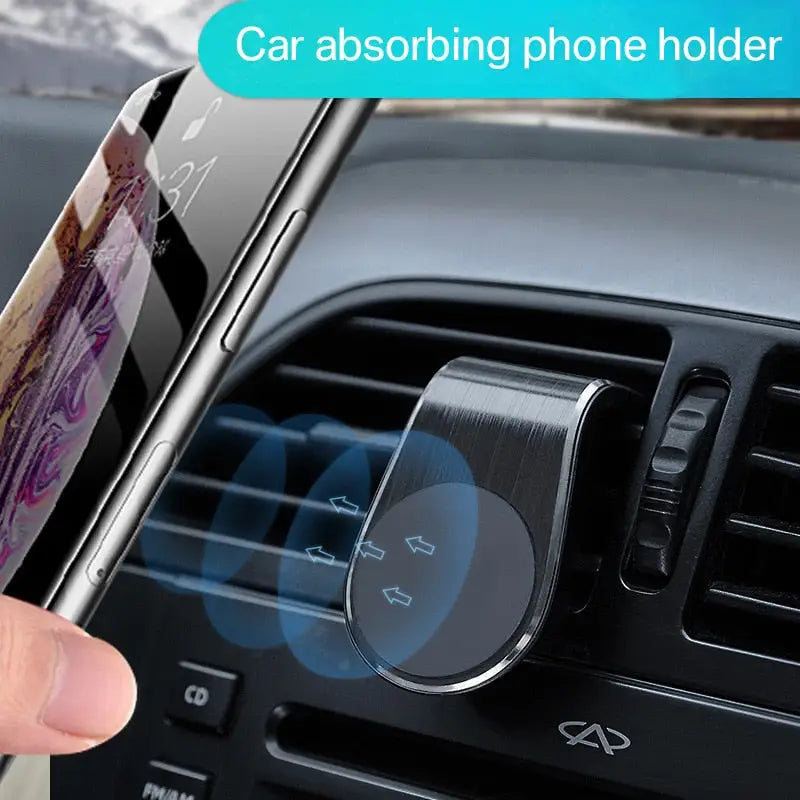 a hand holding a phone in the dashboard of a car