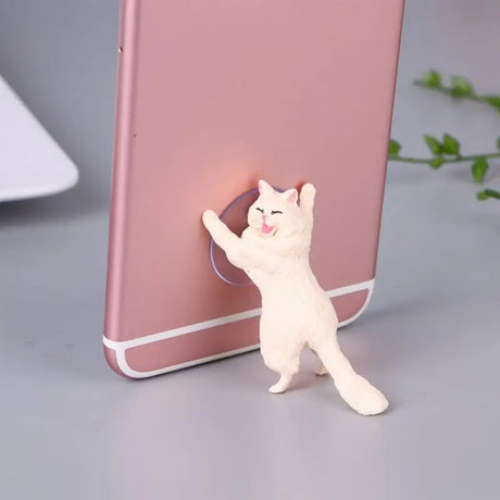 a cat is standing on its hinds while the phone is on the table