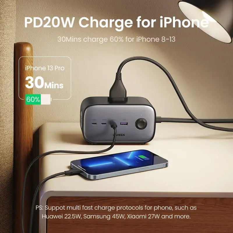 A phone charging station with a phone and a lamp