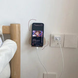 a cell phone is plugged into a wall outlet