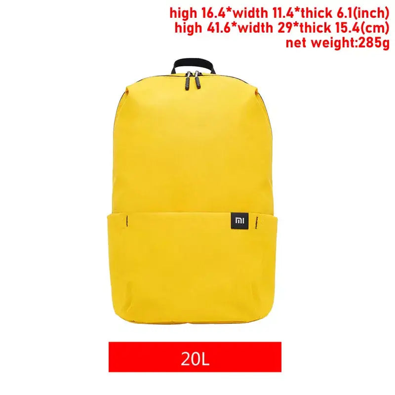 a picture of a yellow backpack with a black handle and a red tag