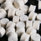 a pile of white sugar cubes on a black surface