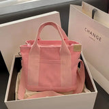 a pink bag with a white box and a pink purse
