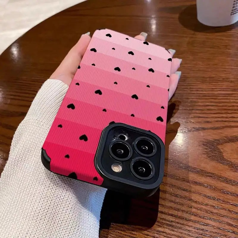 a pink and black iphone case with hearts on it