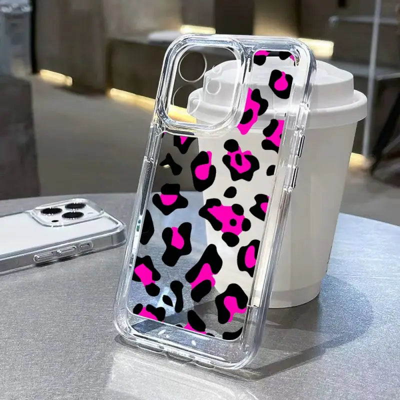 a pink and black leopard print phone case on a table