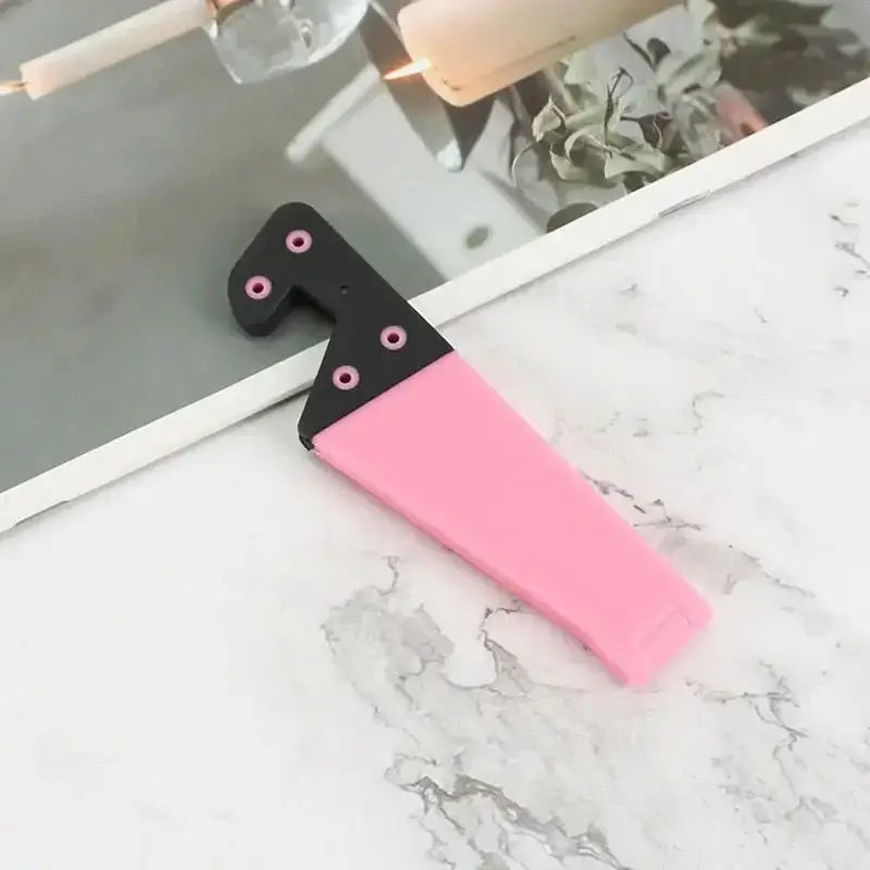 a pink and black knife on a marble counter
