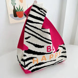a pink and black purse with a zebra print