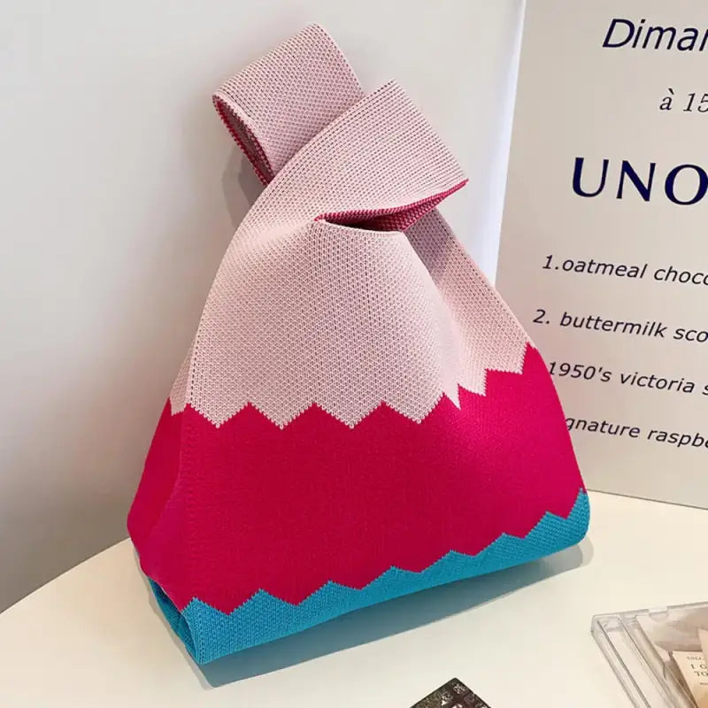 a pink and blue bag sitting on top of a table