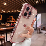 Pink clear phone case with a heart design and camera lens protectors.