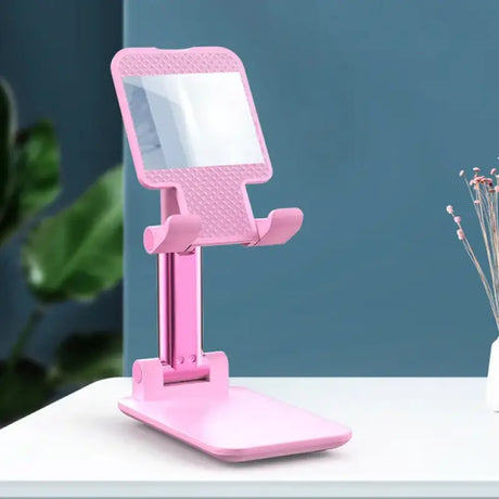 A pink desk lamp with a mirror on it