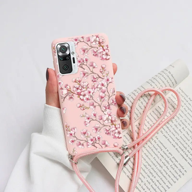 a woman holding a pink phone case with a pink flower design