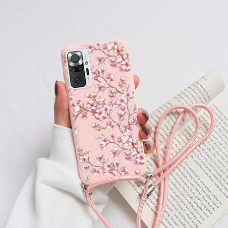 a woman holding a pink phone case with a pink flower design