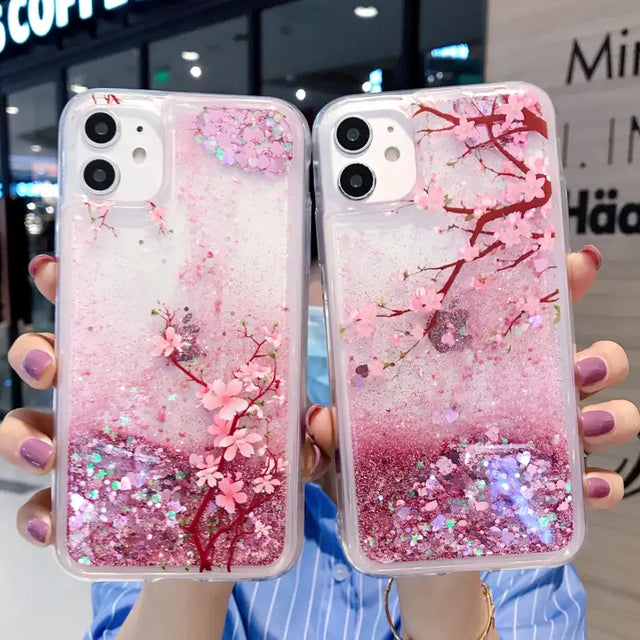 a woman holding two pink glitter phone cases