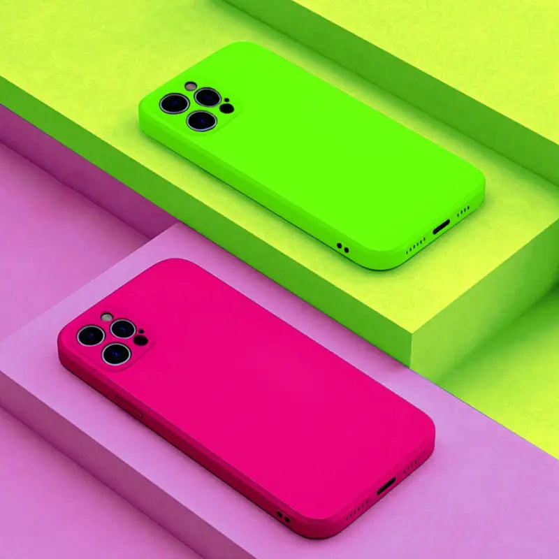 a pink and green iphone case sitting on top of a pile of colorful boxes