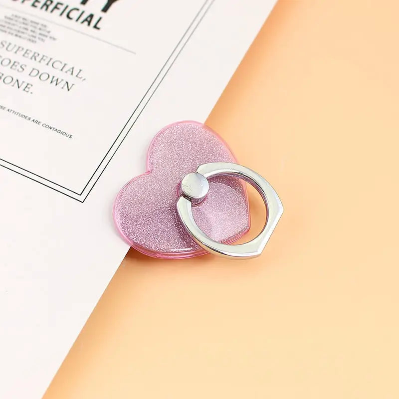 a pink heart shaped ring on top of a white book