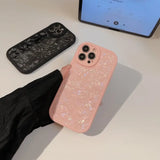 a pink phone case sitting on top of a white table
