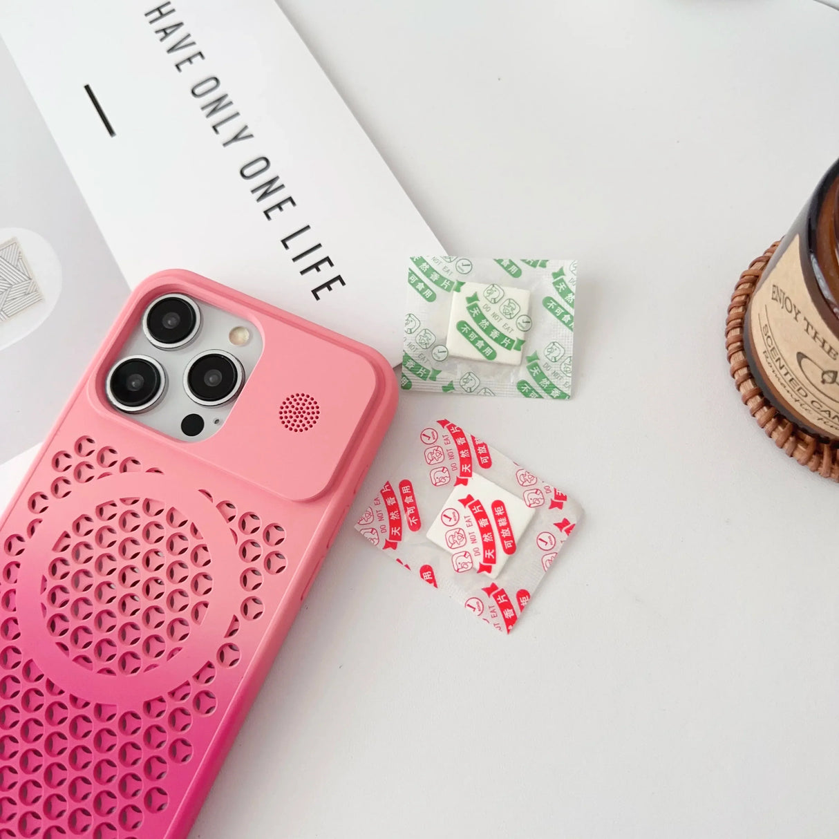 Pink iPhone case with a perforated geometric pattern.