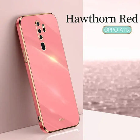 The back of a pink iphone with a gold frame