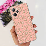 a woman holding a pink and gold leopard print case