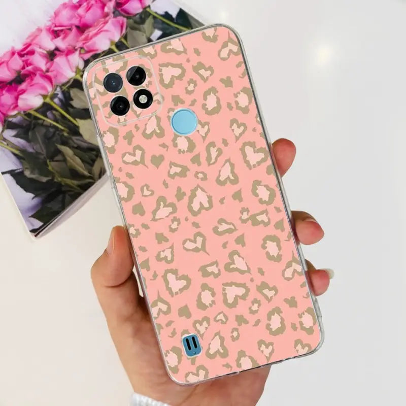 a person holding a pink and gold leopard print case