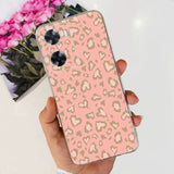 a woman holding a pink and gold leopard print phone case