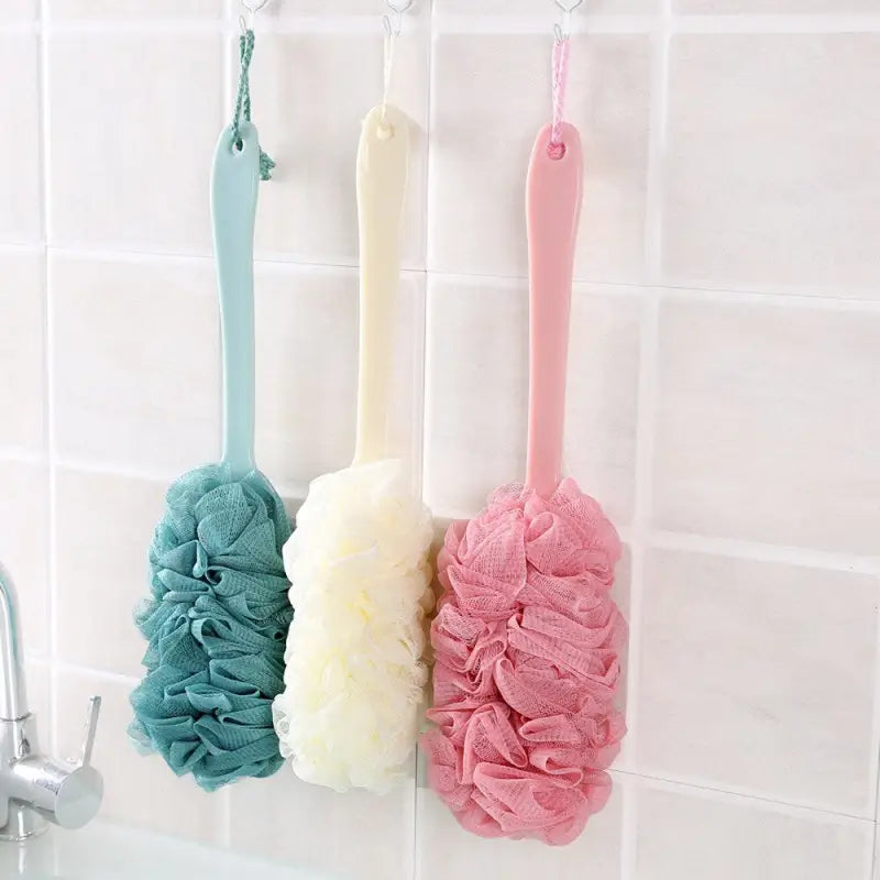a bathroom shower with three colorful towels hanging on the wall