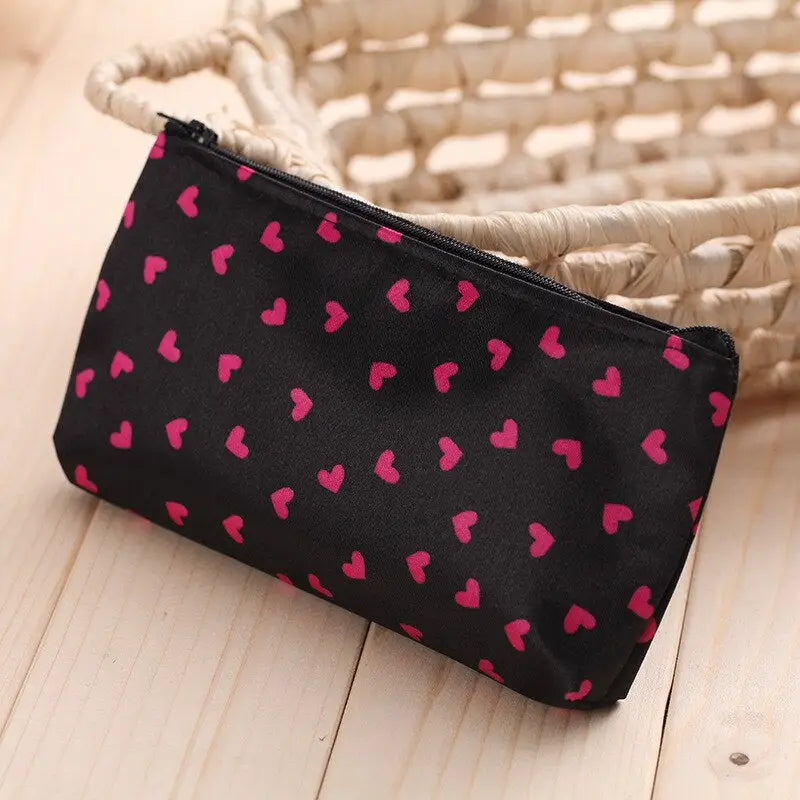 a black and pink heart print bag with a rope handle