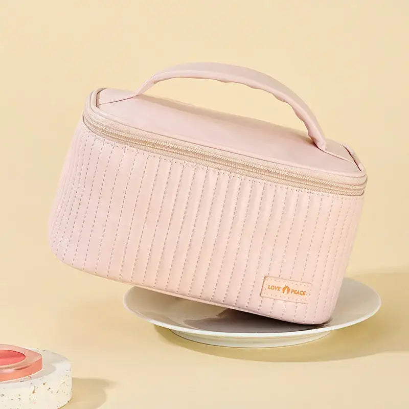 a pink makeup bag with a pink handle