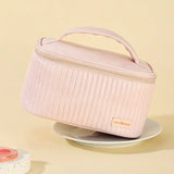 a pink makeup bag with a pink handle