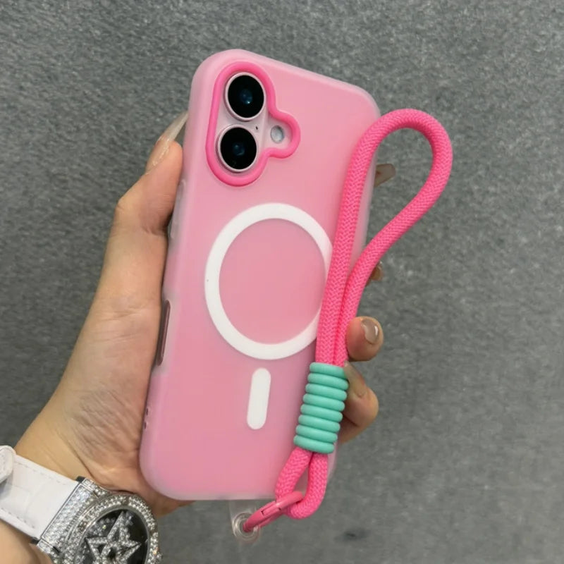 Pink phone case with a camera cutout, a white magnetic charging ring, and an attached pink and teal braided wrist strap.