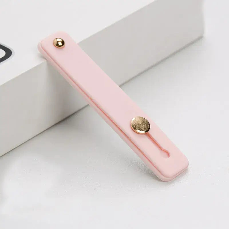 a pink phone case with a gold button