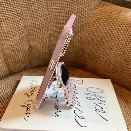 a pink phone sitting on top of a book