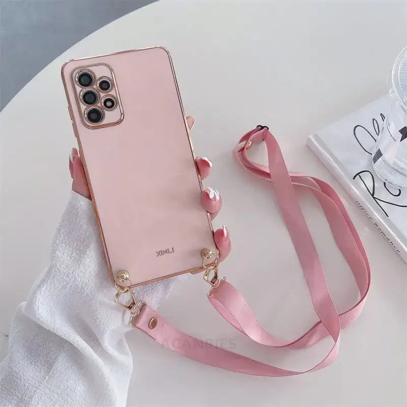 A pink phone case with a pink strap on a white table