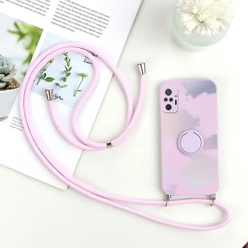a pink phone case with a white flower and a pink cord