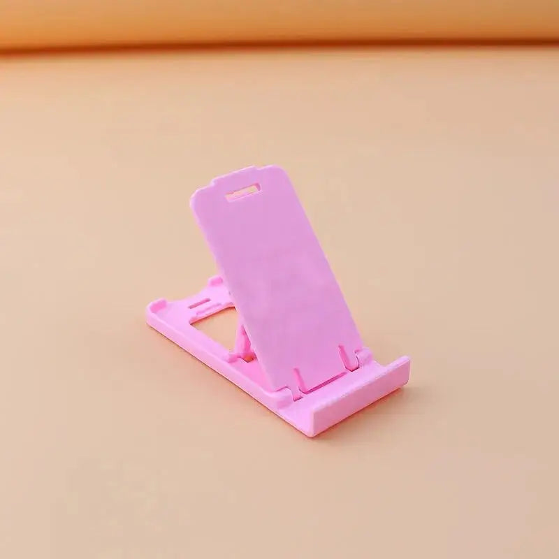 a pink phone stand on a beige surface