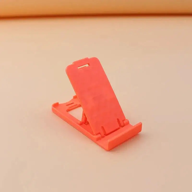 a pink phone stand on a white surface